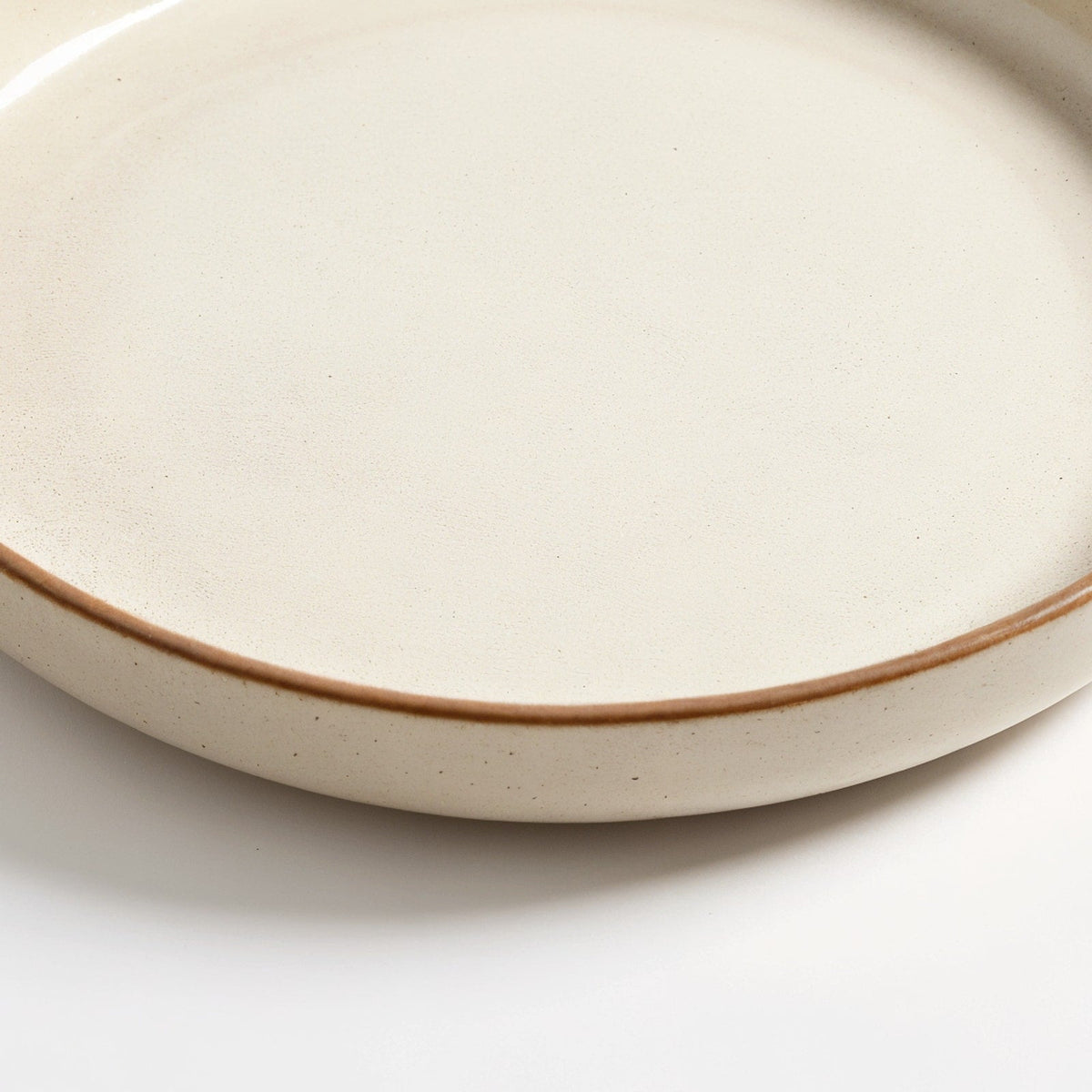 Danmero Alabaster Serving Plate — macro close-up of the raised rim and glaze pooling